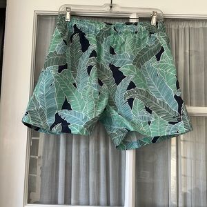 Green and blue tropical print swim trunks, side pockets, mesh lining,